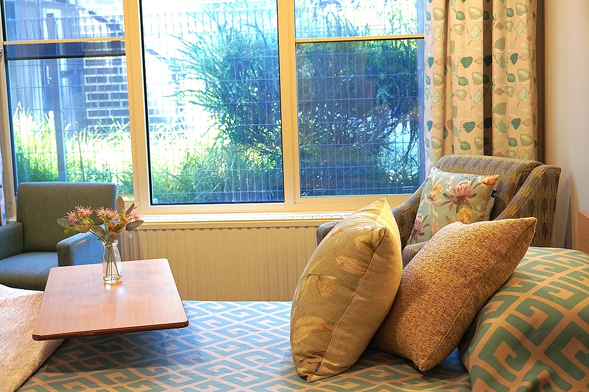 A cosy bed with decorative pillows in a private aged care room at Samarinda Lodge, BASSCARE's Ashburton residential aged care home.